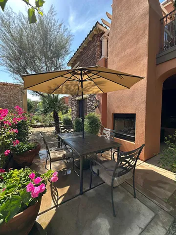 a view of a table and chairs under an umbrella in the patio