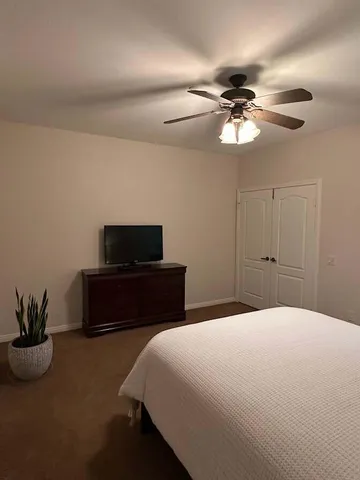 a bedroom with a bed and a potted plant