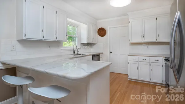 a kitchen with a sink cabinets and wooden floor