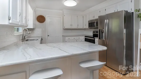 a kitchen with stainless steel appliances a sink and a refrigerator