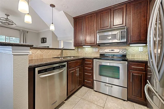 a kitchen with granite countertop a stove sink and cabinets