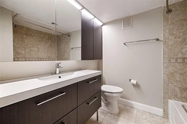 a bathroom with a sink a toilet a mirror and shower