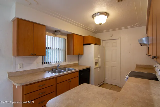 a kitchen with a sink cabinets and a refrigerator