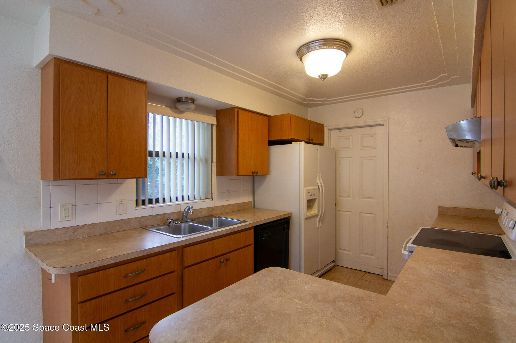 981 Palmer Street Rockledge, FL 32955 - Photo 14 of 38 a kitchen with a sink cabinets and a refrigerator