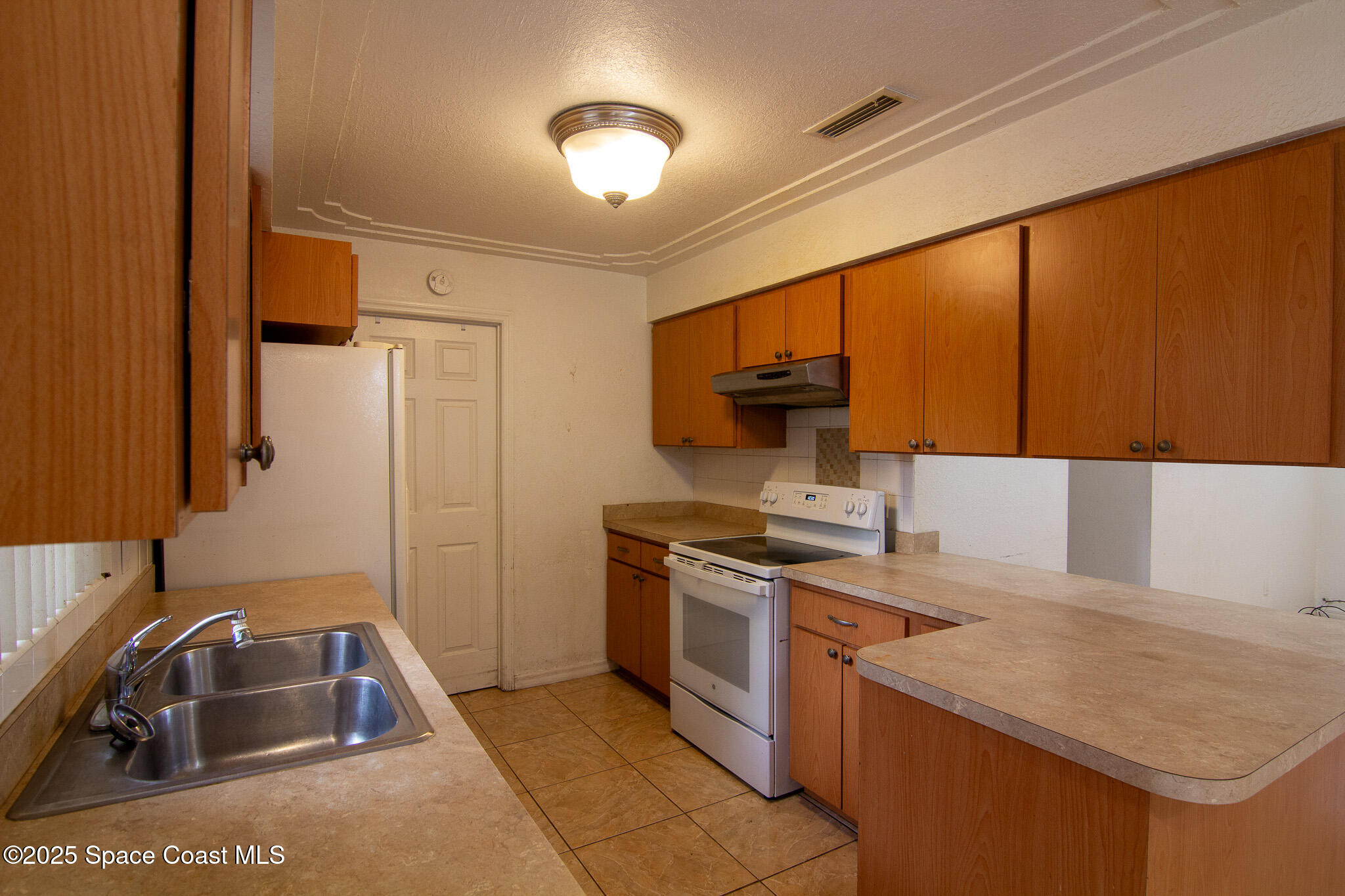 981 Palmer Street Rockledge, FL 32955 - Photo 15 of 38 a kitchen that has a sink and a stove