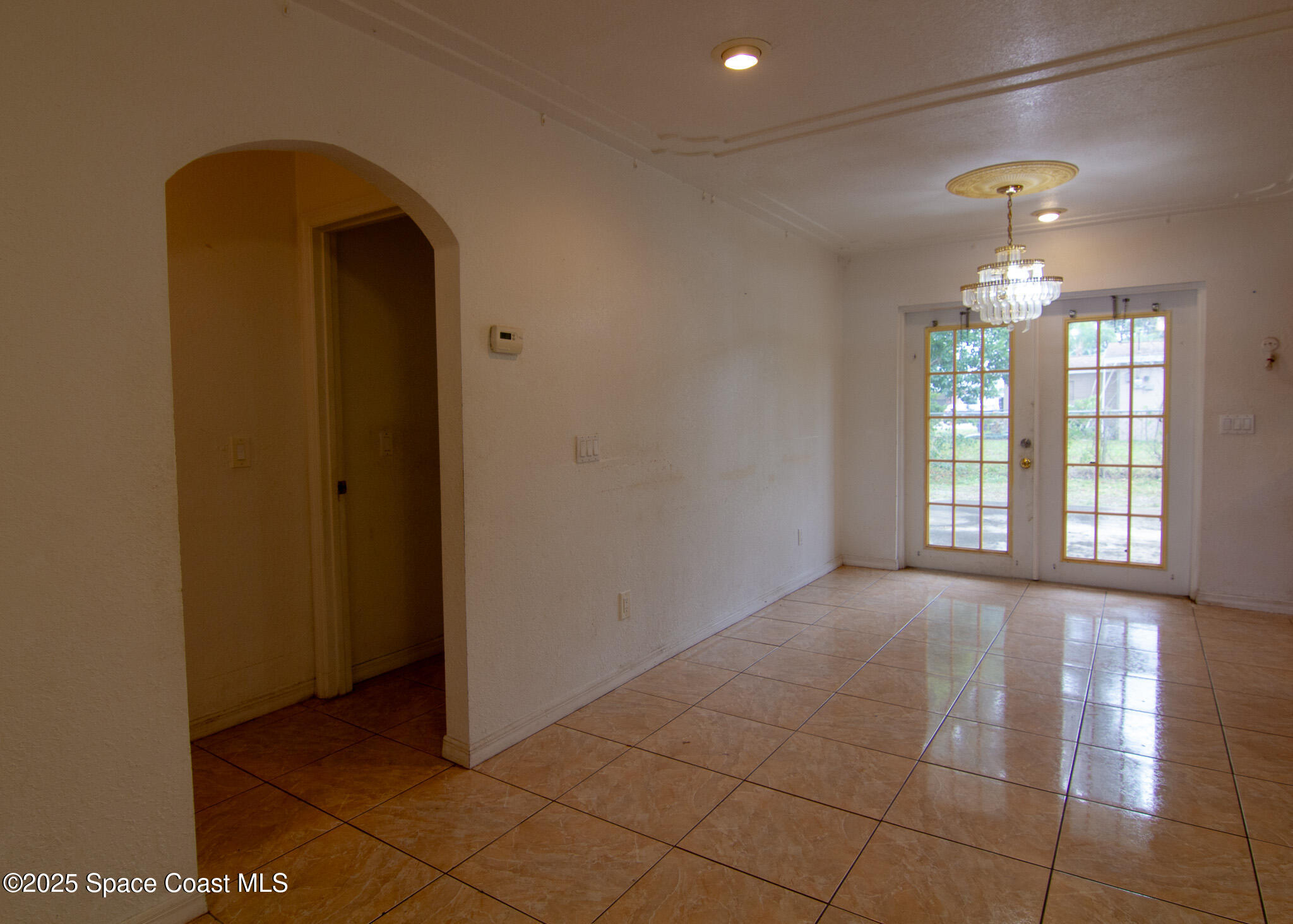 981 Palmer Street Rockledge, FL 32955 - Photo 24 of 38 a view of an empty room with chandelier fan and fire place