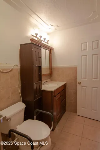 a bathroom with a granite countertop toilet and a sink