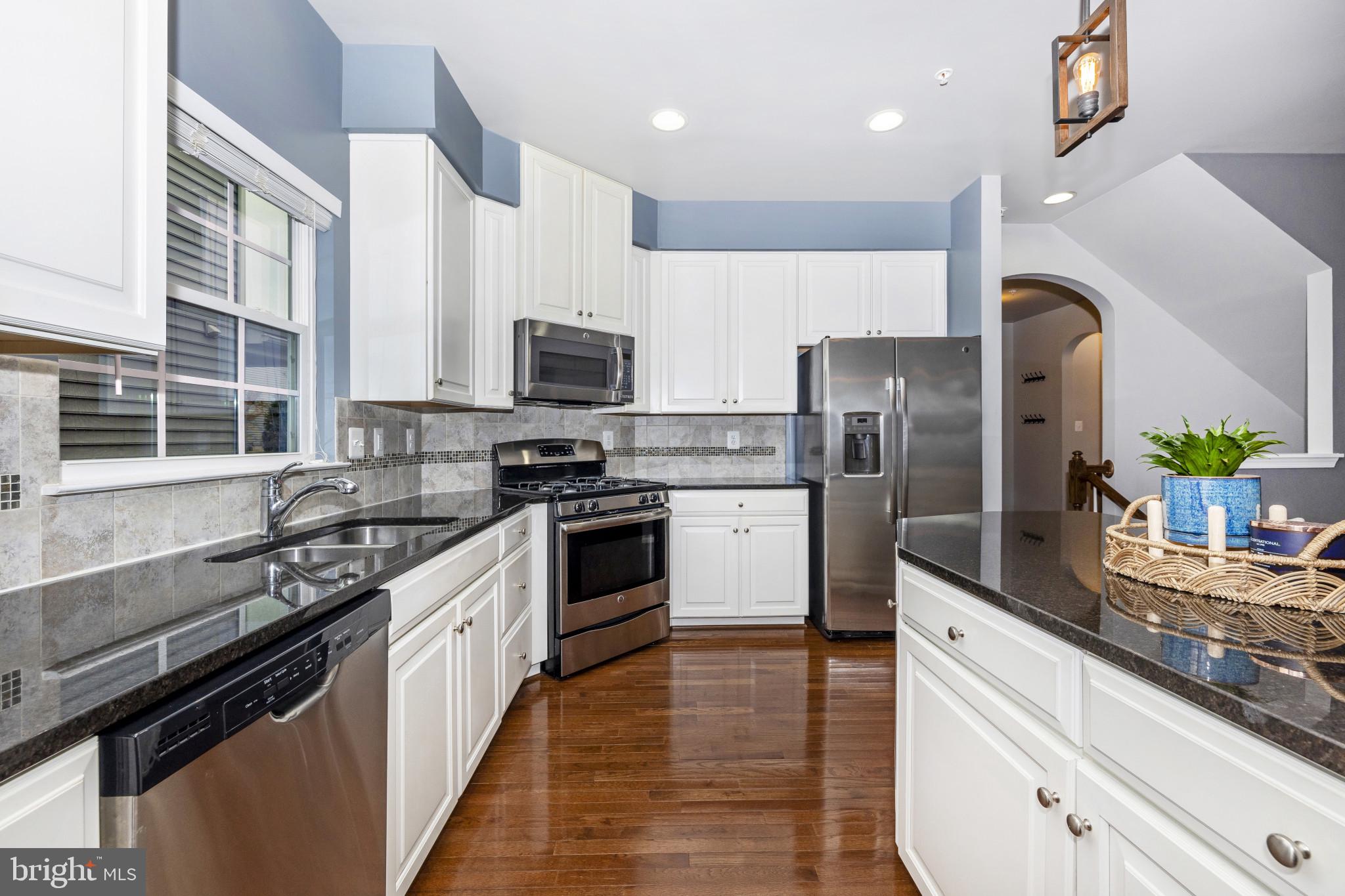 1912 Regiment Way Frederick, MD 21702 - Photo 12 of 45 a kitchen with stainless steel appliances a sink dishwasher a refrigerator a stove top oven a sink and dishwasher with wooden floor