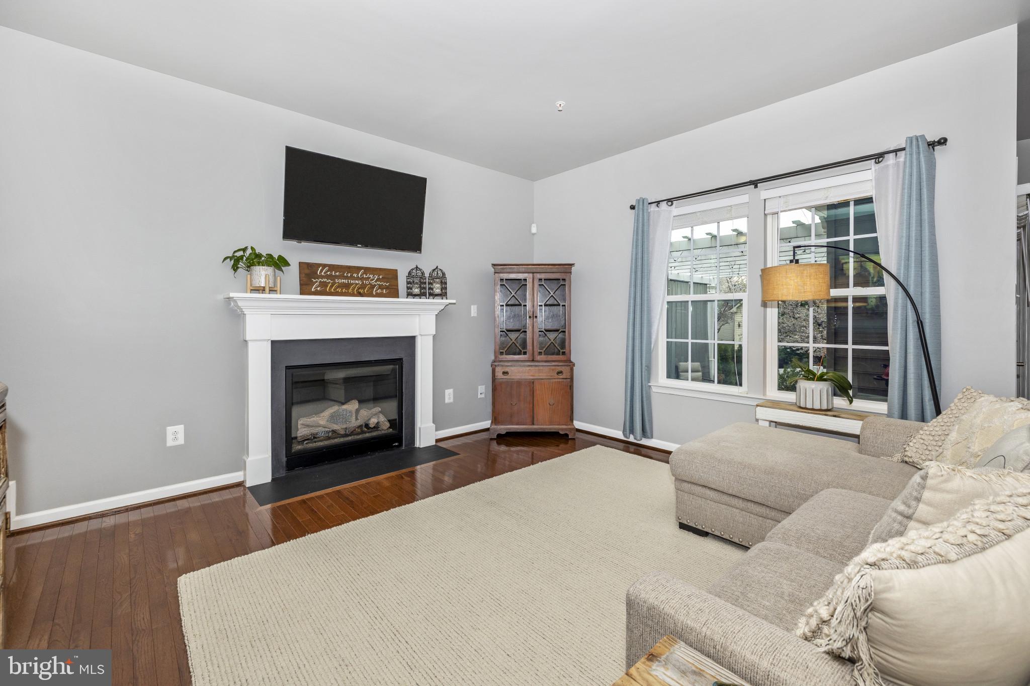 1912 Regiment Way Frederick, MD 21702 - Photo 16 of 45 a living room with furniture a flat screen tv and a fireplace