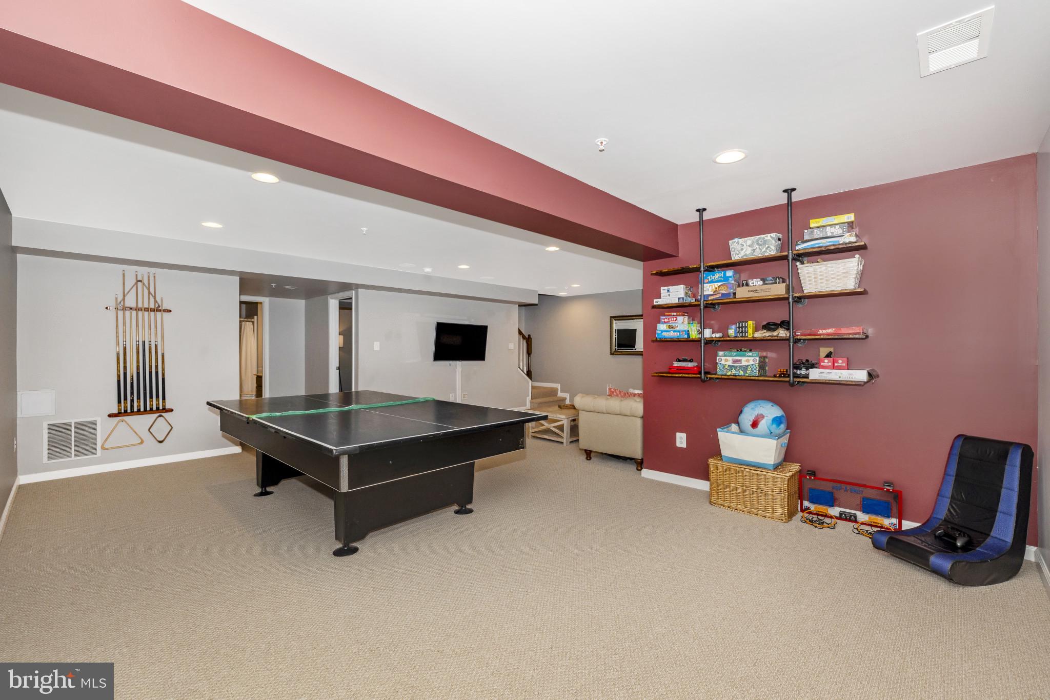 1912 Regiment Way Frederick, MD 21702 - Photo 36 of 45 a living room with furniture a flat screen tv and gym equipment