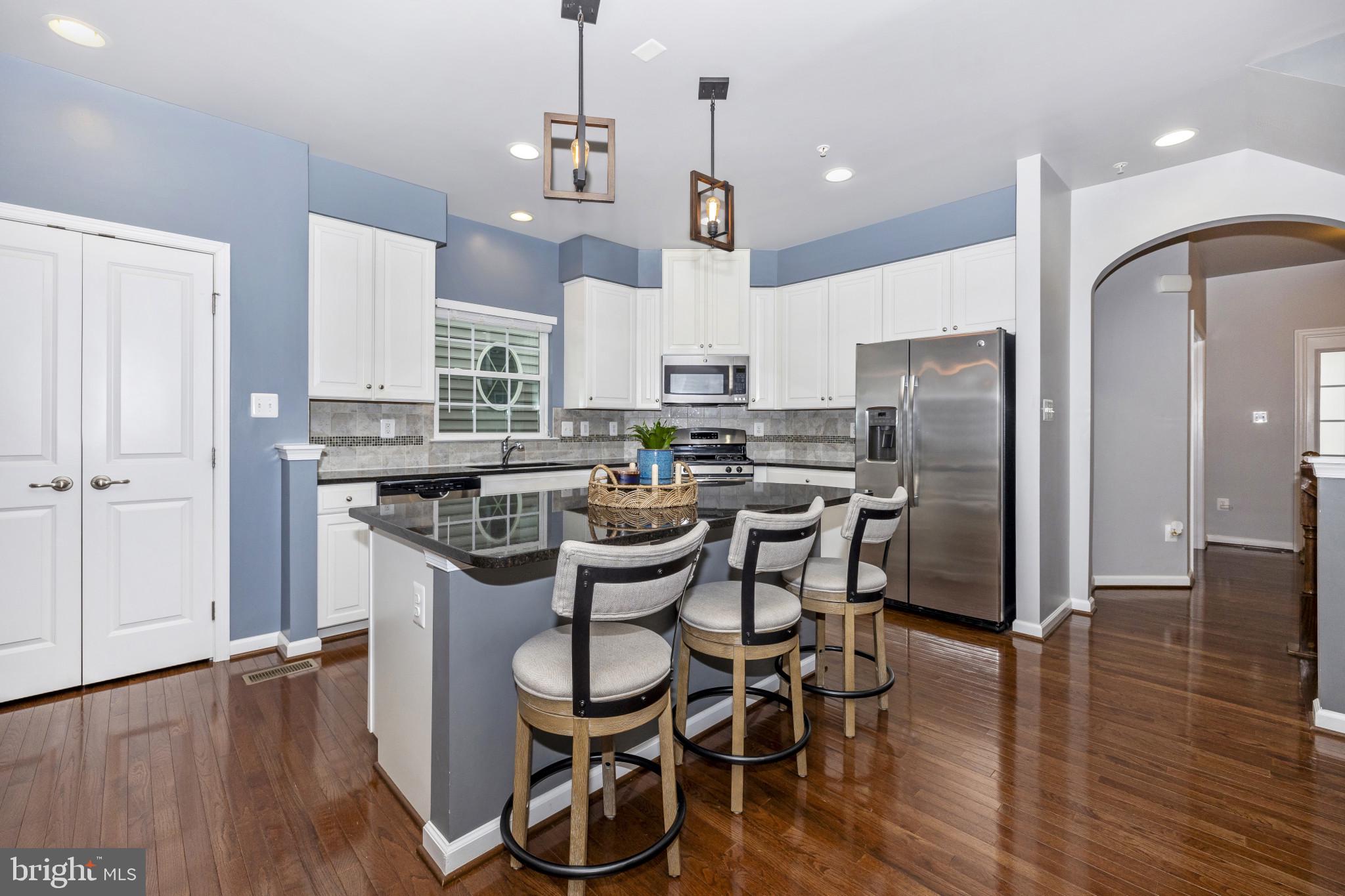 1912 Regiment Way Frederick, MD 21702 - Photo 10 of 45 a kitchen with stainless steel appliances a dining table chairs stove and refrigerator
