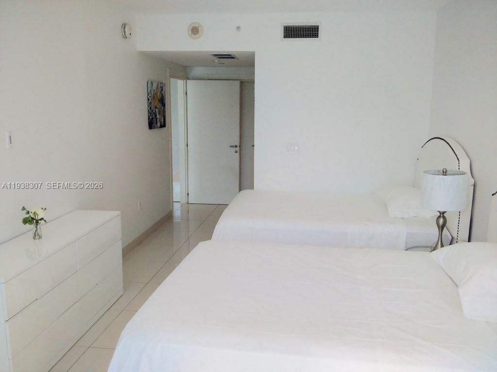 200 Biscayne Blvd Way, Unit 906 Miami, FL 33131 - Photo 11 of 44 a bedroom with a bed and a sink