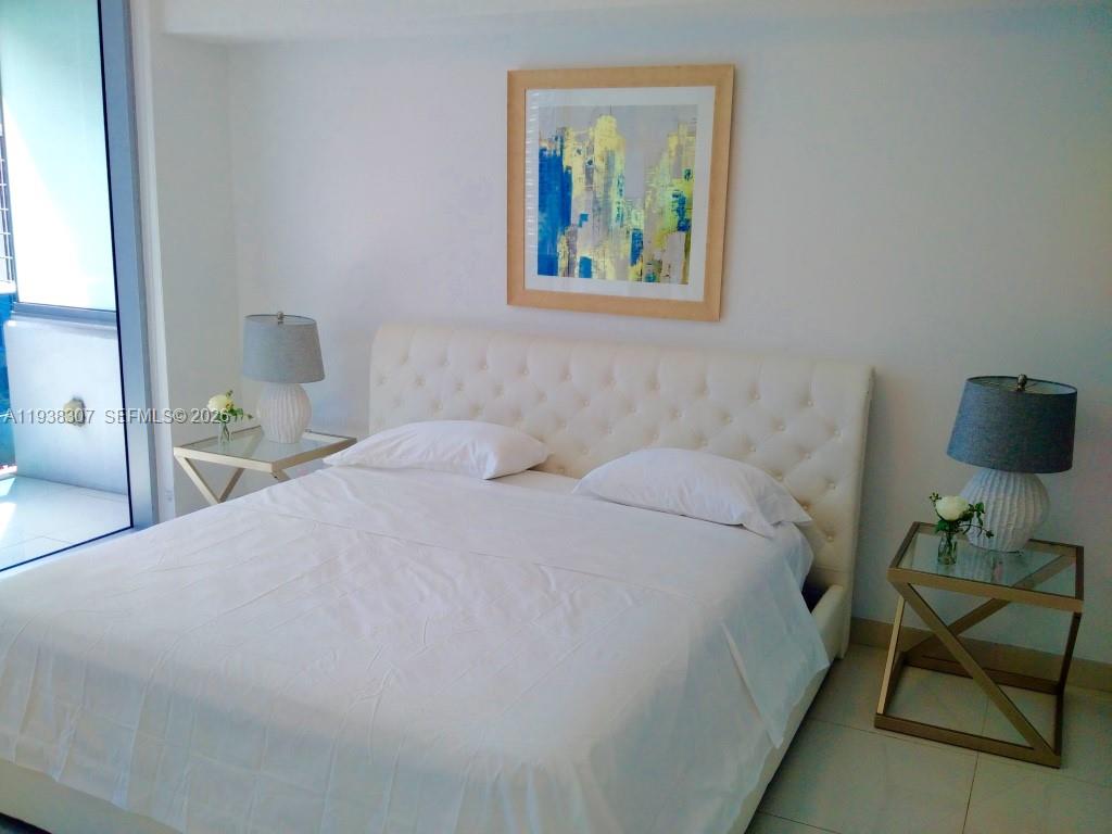 200 Biscayne Blvd Way, Unit 906 Miami, FL 33131 - Photo 2 of 44 a bedroom with a bed and a lamp on dresser