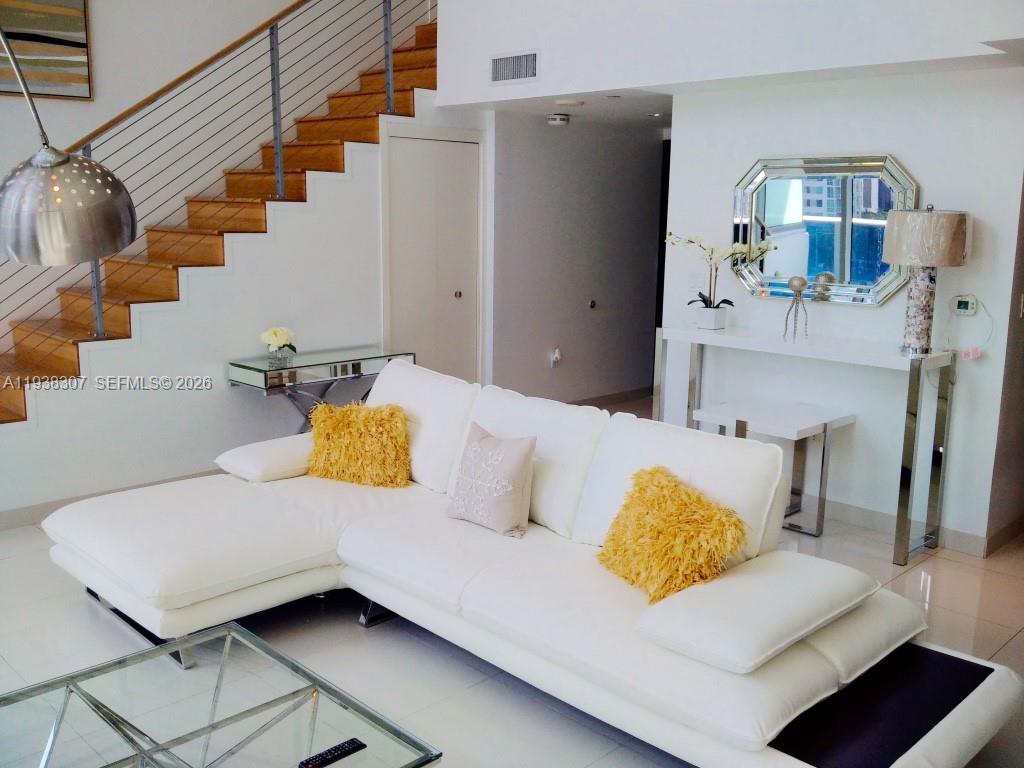 200 Biscayne Blvd Way, Unit 906 Miami, FL 33131 - Photo 23 of 44 a living room with furniture and a view of kitchen