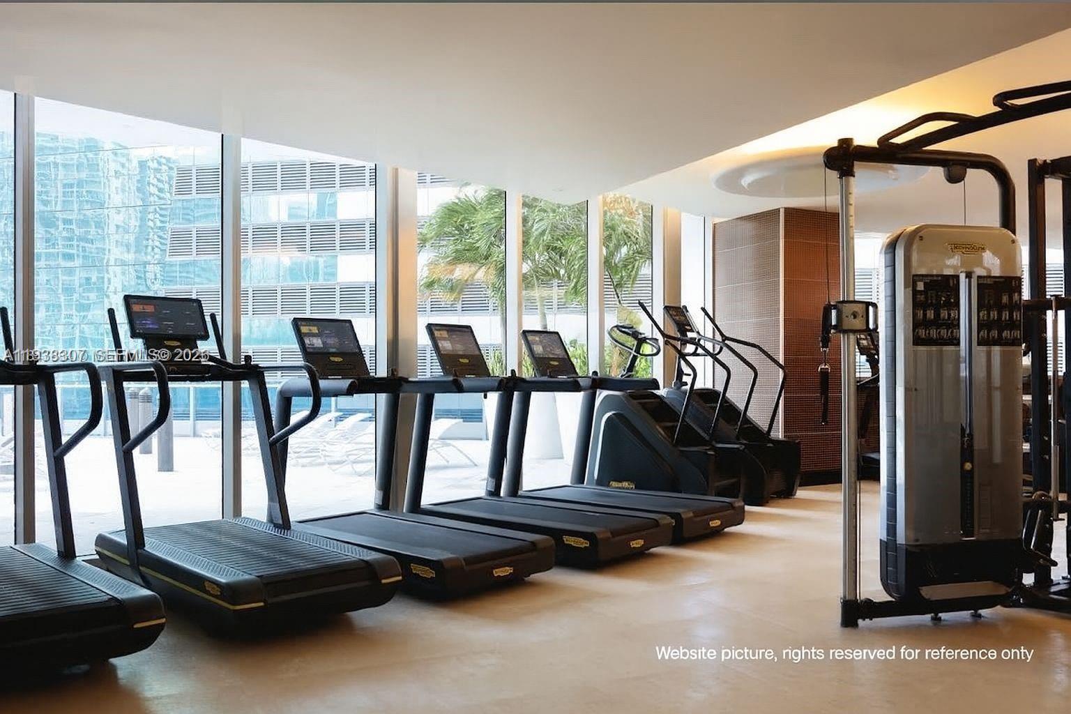 200 Biscayne Blvd Way, Unit 906 Miami, FL 33131 - Photo 34 of 44 a room with gym equipment and floor to ceiling window