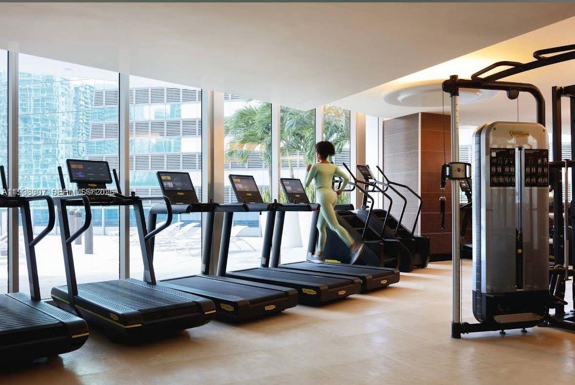 200 Biscayne Blvd Way, Unit 906 Miami, FL 33131 - Photo 37 of 44 a room with gym equipment and large windows