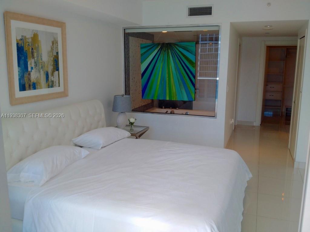 200 Biscayne Blvd Way, Unit 906 Miami, FL 33131 - Photo 5 of 44 a bedroom with a bed and a chair