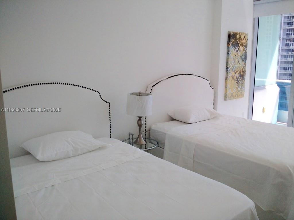 200 Biscayne Blvd Way, Unit 906 Miami, FL 33131 - Photo 9 of 44 a bedroom with a bed and a mirror