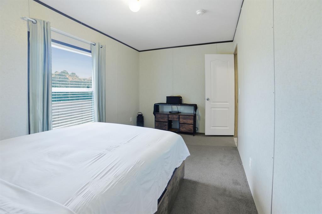127 Almond Road Minden, LA 71055 - Photo 22 of 25 a bedroom with a bed and a chandelier
