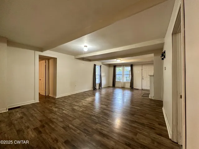 a view of an empty room and wooden floor