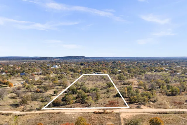 an aerial view of a house with a mountain