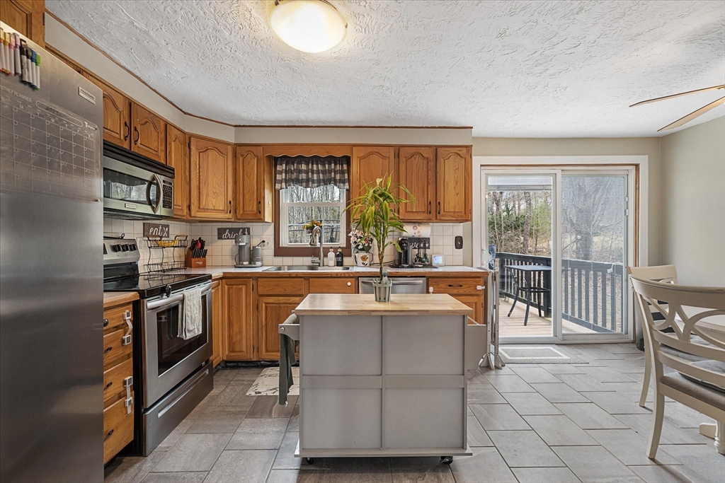7 Hebert Road Spencer, MA 01562 - Photo 11 of 32 a kitchen with kitchen island granite countertop a sink and a stove top oven