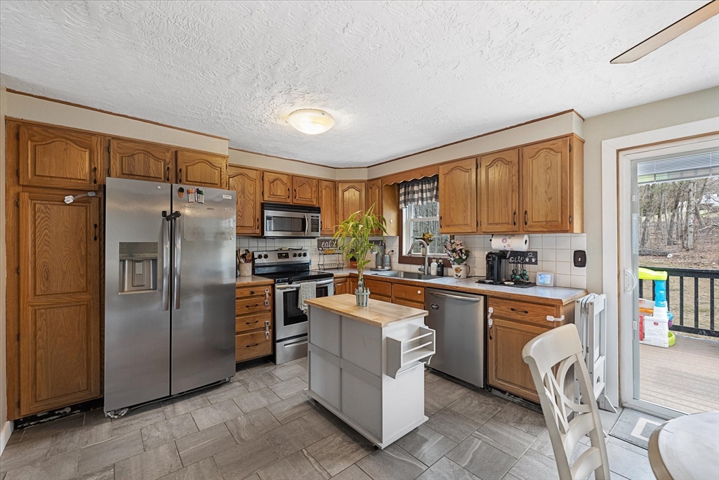 7 Hebert Road Spencer, MA 01562 - Photo 9 of 32 a kitchen with stainless steel appliances granite countertop a refrigerator and a stove top oven