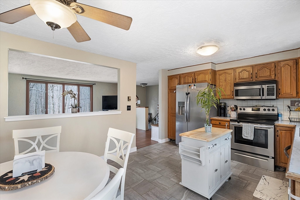 7 Hebert Road Spencer, MA 01562 - Photo 10 of 32 a living room with furniture a flat screen tv and kitchen view