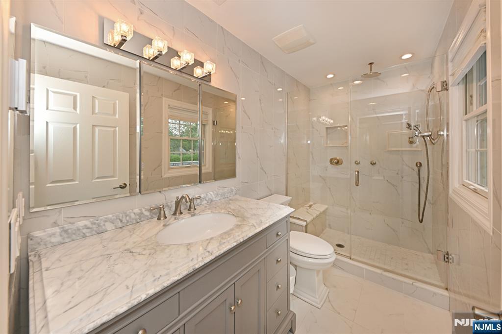 40 Plymouth Road Hillsdale, NJ 07642 - Photo 13 of 33 a bathroom with a granite countertop sink a toilet a shower and a mirror