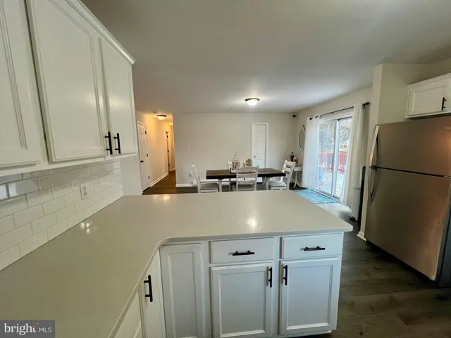 an empty room with ceiling fan and windows