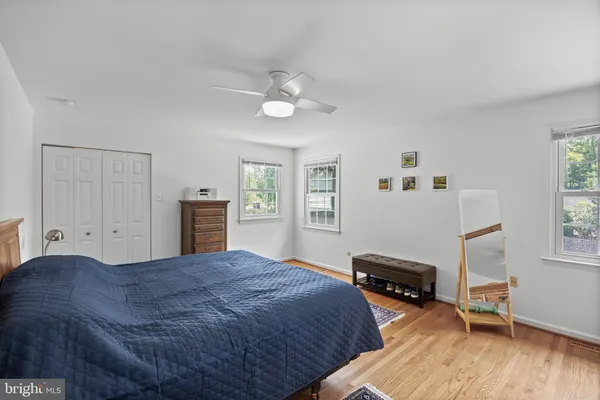 a spacious bedroom with a bed dresser and a window