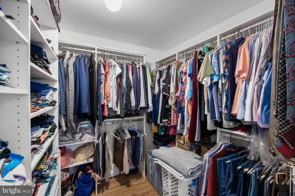 a view of walk in closet with clothes