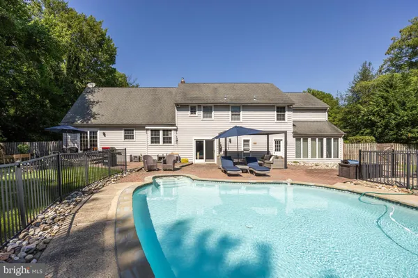 a view of a house with swimming pool and sitting area