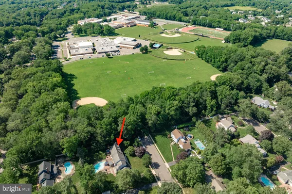 an aerial view of residential houses with outdoor space and trees