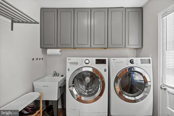 a utility room with sink dryer and washer