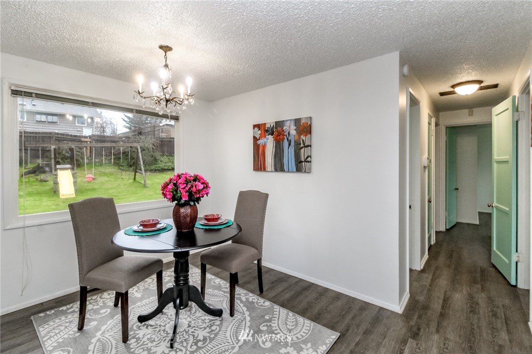 7901 Leschi Road Southwest Lakewood, WA 98498 - Photo 8 of 33 a dining room with furniture a chandelier and wooden floor