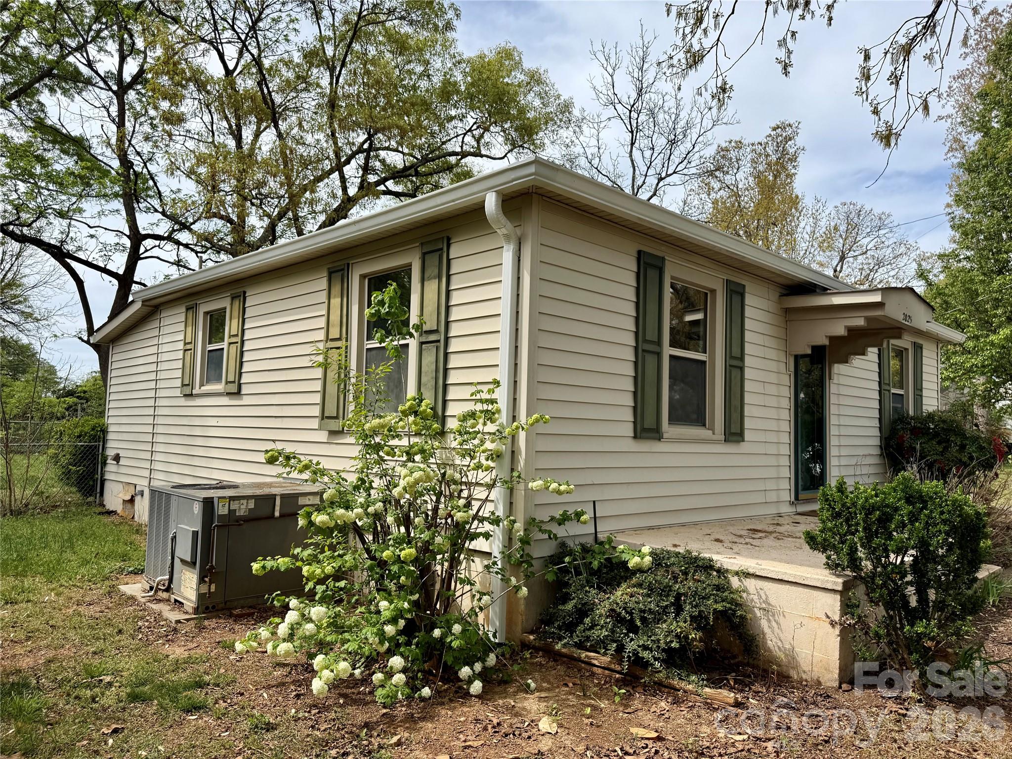 2025 28th Street Northeast Hickory, NC 28601 - Photo 17 of 17 a small white house with a white bench and large trees