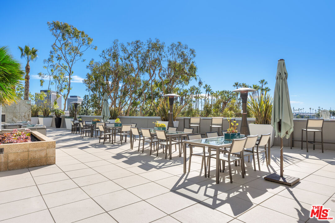 13650 Marina Pointe Drive, Unit 908 Marina del Rey, CA 90292 - Photo 30 of 33 a view of a patio with dining table and chairs with plants