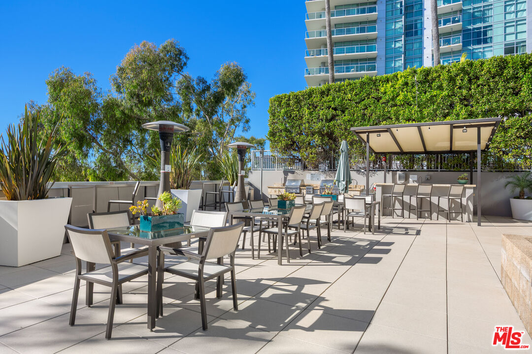 13650 Marina Pointe Drive, Unit 908 Marina del Rey, CA 90292 - Photo 32 of 33 a view of a patio with a table and chairs and potted plants