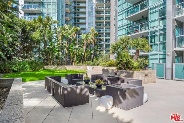 a view of a patio with table and chairs potted plants and palm trees
