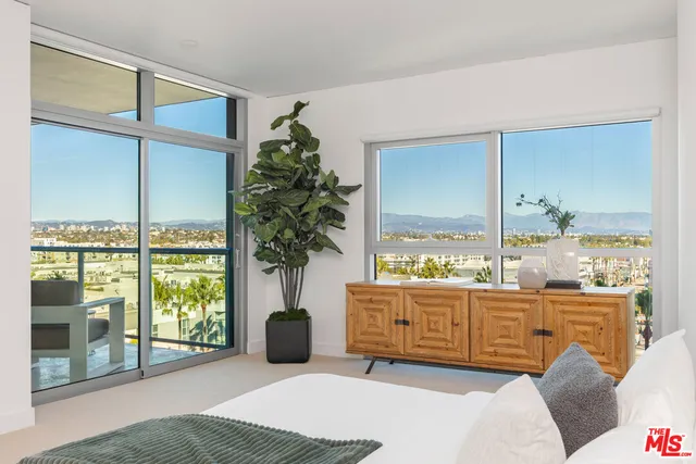 a bedroom with furniture and large windows