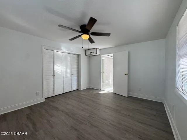 a view of empty room with wooden floor and window