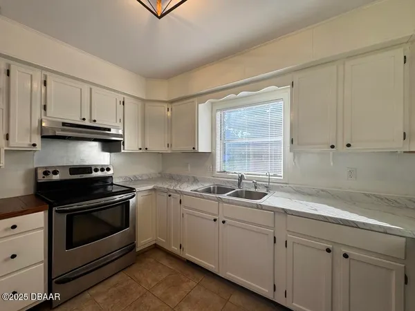 a kitchen with stainless steel appliances granite countertop a sink a stove a microwave and cabinets