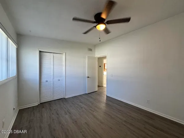 a view of an empty room with wooden floor