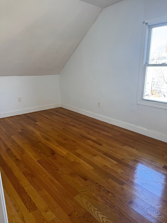 61 Crescent Avenue, Unit 4 Chelsea, MA 02150 - Photo 4 of 9 an empty room with wooden floor and windows