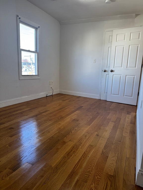 61 Crescent Avenue, Unit 4 Chelsea, MA 02150 - Photo 5 of 9 a view of an empty room with wooden floor and a window