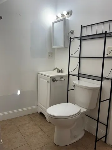 a white toilet sitting next to a shower