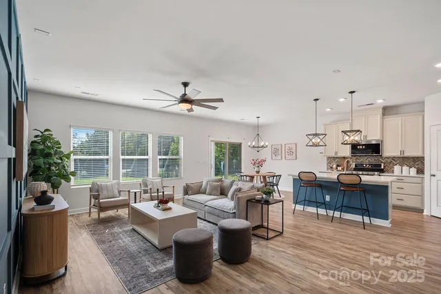 a living room with furniture kitchen view and a large window