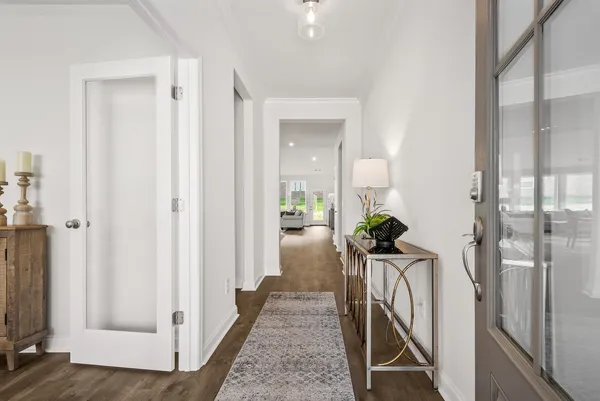 a view of a hallway with wooden floor and a living room