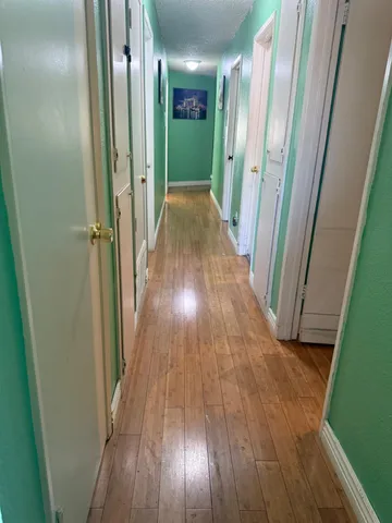 a view of a hallway with wooden floor